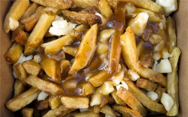 <strong>Poutine (Canada): </strong> Poutin là món ăn vặt phổ biến trên các đường phố của Canada, đặc biệt là ở Québec. Món ăn này gồm khoai tây chiên thấm đẫm nước thịt và phô mai.