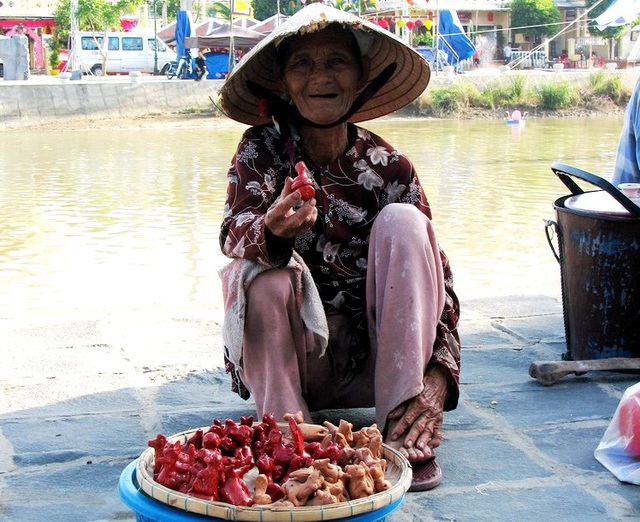 Một người bán con Tò-he bên bờ sông Hoài nở nụ cười thân thiện với du khách